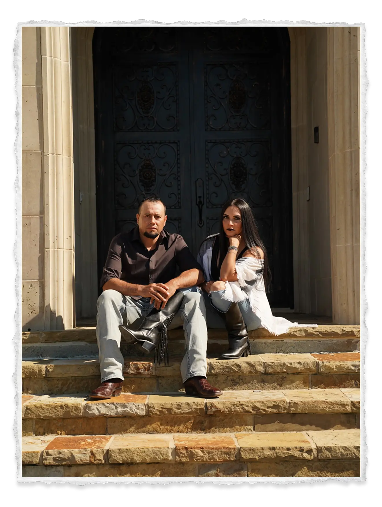 Fabian and his wife sitting on a staircase in front of a doorway