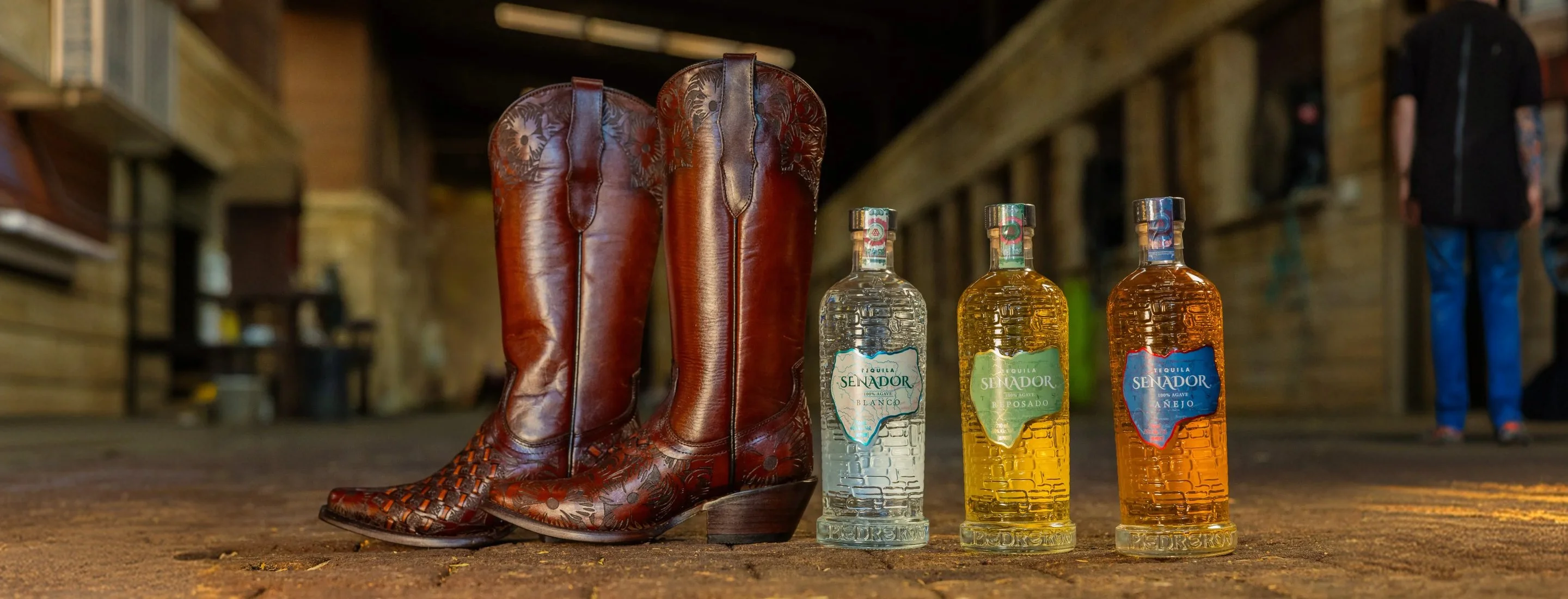 The Foundation 13 Handcrafted tooled boots and three Senador bottles in a stable aisle