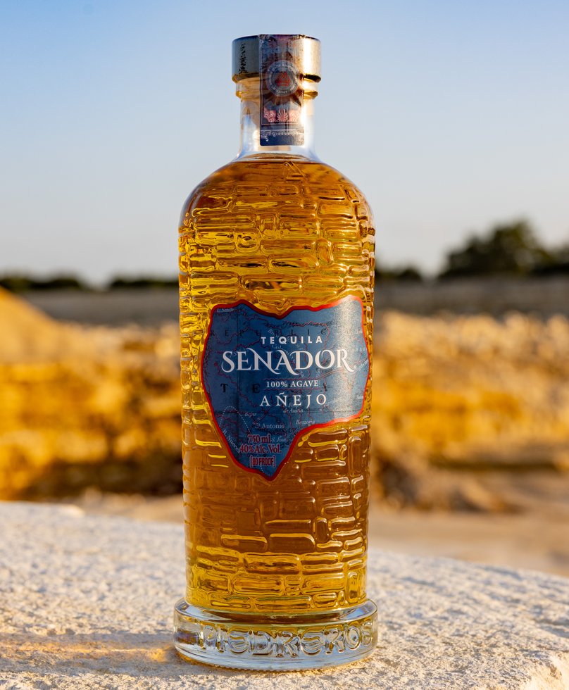 Senador Añejo tequila on a limestone ledge at golden hour