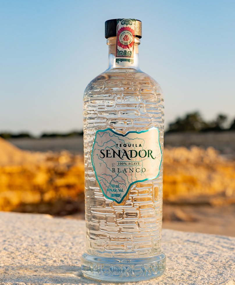 Senador Blanco tequila on a limestone ledge at golden hour